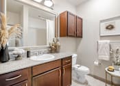 Thumbnail 32 of 35 - A bathroom with a white toilet and a white sink.