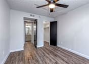Thumbnail 23 of 66 - an empty living room with a ceiling fan and a door to a bathroom