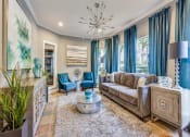 Thumbnail 19 of 24 - a living room with blue curtains and a chandelier