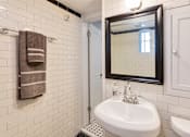 Thumbnail 9 of 23 - A white sink in a bathroom with a mirror above it.