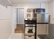 Thumbnail 3 of 23 - A kitchen with a stove top oven and microwave.