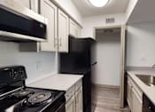 Thumbnail 1 of 66 - a kitchen with white cabinets and black appliances and a black refrigerator
