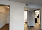 Thumbnail 6 of 66 - an empty living room with a door to a bathroom and a kitchen