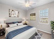 Thumbnail 1 of 14 - A bedroom with a bed, nightstands, and a ceiling fan.