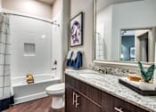 Thumbnail 7 of 22 - A bathroom with a white toilet, a white sink, and a white bathtub.