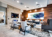 Thumbnail 13 of 22 - A modern living room with a stone fireplace and a large abstract painting on the wall.