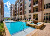 Thumbnail 20 of 22 - A swimming pool in front of apartment buildings.