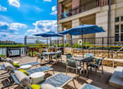 Thumbnail 22 of 22 - A patio with a table and chairs under umbrellas.