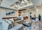 Thumbnail 16 of 22 - A modern living room with a grey sofa and a coffee table.