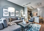 Thumbnail 5 of 22 - A grey couch with a grey and white rug in front of it.