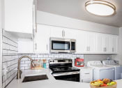 Thumbnail 22 of 25 - a kitchen with white cabinets and a sink and a microwave
