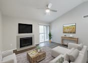 Thumbnail 2 of 31 - A living room with a fireplace and a flat screen TV mounted on the wall.