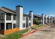 Thumbnail 36 of 66 - a row of townhomes on a street in front of a blue sky
