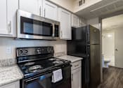 Thumbnail 42 of 66 - a kitchen with black appliances and white cabinets and a black refrigerator