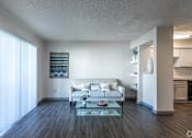 Thumbnail 30 of 66 - a living room with a white couch and a glass coffee table