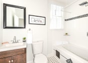 Thumbnail 15 of 23 - A white toilet sits next to a sink in a bathroom.