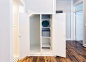 Thumbnail 17 of 23 - A white kitchen cabinet with a glass door and shelves.