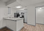 Thumbnail 58 of 66 - an open kitchen and living room with a marble counter top and a refrigerator