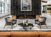 Thumbnail 14 of 35 - A modern living room with a fireplace and a large painting above it.