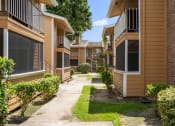 Thumbnail 22 of 35 - a pathway lined with yellow and brown condominiums