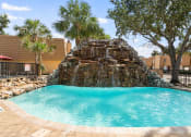 Thumbnail 17 of 54 - a large pool with a rock waterfall in the middle of it