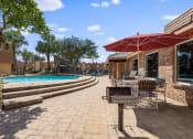 Thumbnail 20 of 54 - a patio with chairs and umbrellas next to a pool