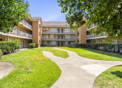 Thumbnail 26 of 29 - a large building with a grassy area in front of it