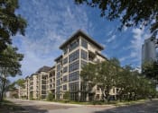 Thumbnail 1 of 23 - a large apartment building on a city street with trees