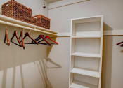 Thumbnail 21 of 25 - a closet with some shelves and some hangers on the wall