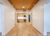 Thumbnail 9 of 15 - A long hallway with a wood ceiling and floor.