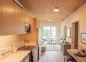Thumbnail 8 of 15 - A kitchen with wooden cabinets and a white countertop.