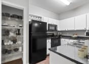 Thumbnail 2 of 32 - a kitchen with black appliances and white cabinets and granite counter tops