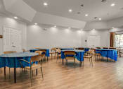 Thumbnail 17 of 22 - A room with tables and chairs set up for an event.