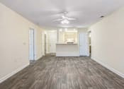 Thumbnail 1 of 22 - A spacious room with wood flooring and a ceiling fan.