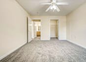 Thumbnail 5 of 22 - A spacious room with a ceiling fan and carpeted floor.
