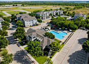 Thumbnail 13 of 14 - A bird's eye view of a residential area with houses, a swimming pool, and a parking lot.