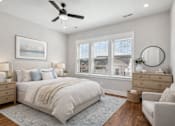 Thumbnail 5 of 38 - A bedroom with a large bed, a ceiling fan, and a painting on the wall.