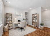 Thumbnail 8 of 38 - A home office with a desk, chair, and shelves.