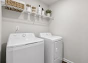 Thumbnail 46 of 56 - A white washing machine and dryer in a small laundry room.