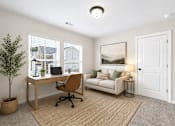 Thumbnail 53 of 56 - A room with a desk, chair, and a couch with a picture on the wall.