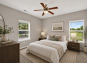 Thumbnail 6 of 20 - A bedroom with a large bed, a ceiling fan, and a view of a green landscape through the windows.
