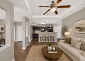 Thumbnail 5 of 20 - A living room with a white couch, a brown coffee table, and a ceiling fan.