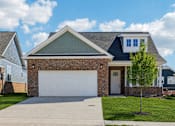 Thumbnail 1 of 38 - A house with a white garage door and a brick facade.
