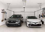 Thumbnail 12 of 38 - Two cars are parked in a garage.