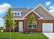 Thumbnail 29 of 38 - A house with a white garage door and a brick facade.