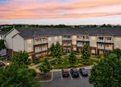 Thumbnail 17 of 17 - A large apartment complex with a parking lot in front.