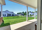 Thumbnail 28 of 33 - A white house with a black fence and a green lawn.