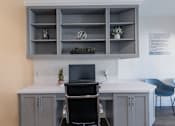 Thumbnail 38 of 53 - A white desk with a black chair and a black laptop on it.