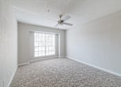 Thumbnail 21 of 53 - A room with a carpet floor, a ceiling fan, and a window.