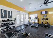 Thumbnail 43 of 53 - A gym with a variety of equipment including dumbbells, treadmills, and a bench press.
